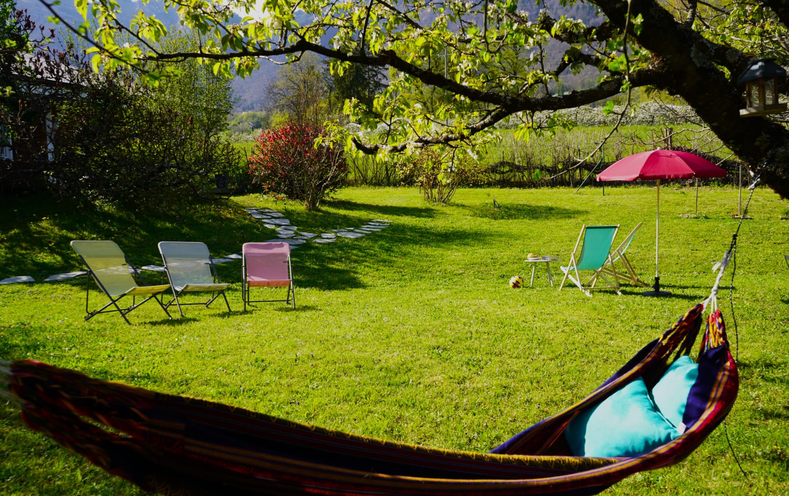 Jardin partagé avec hamac et transats sous les arbres
