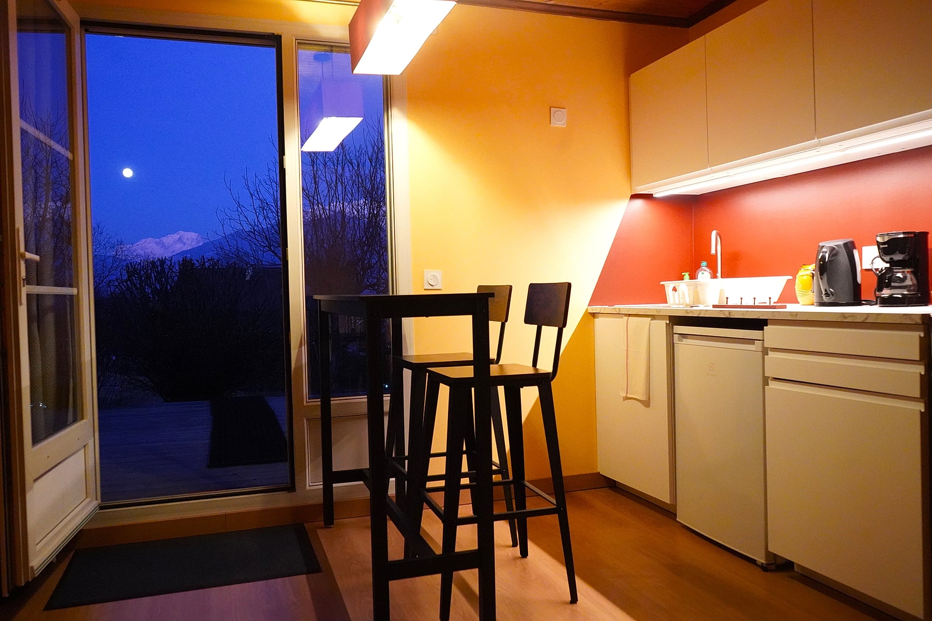 Cuisine du Gîte Vue Blanc de nuit — vue sur le Mont Blanc enneigé depuis la baie vitrée