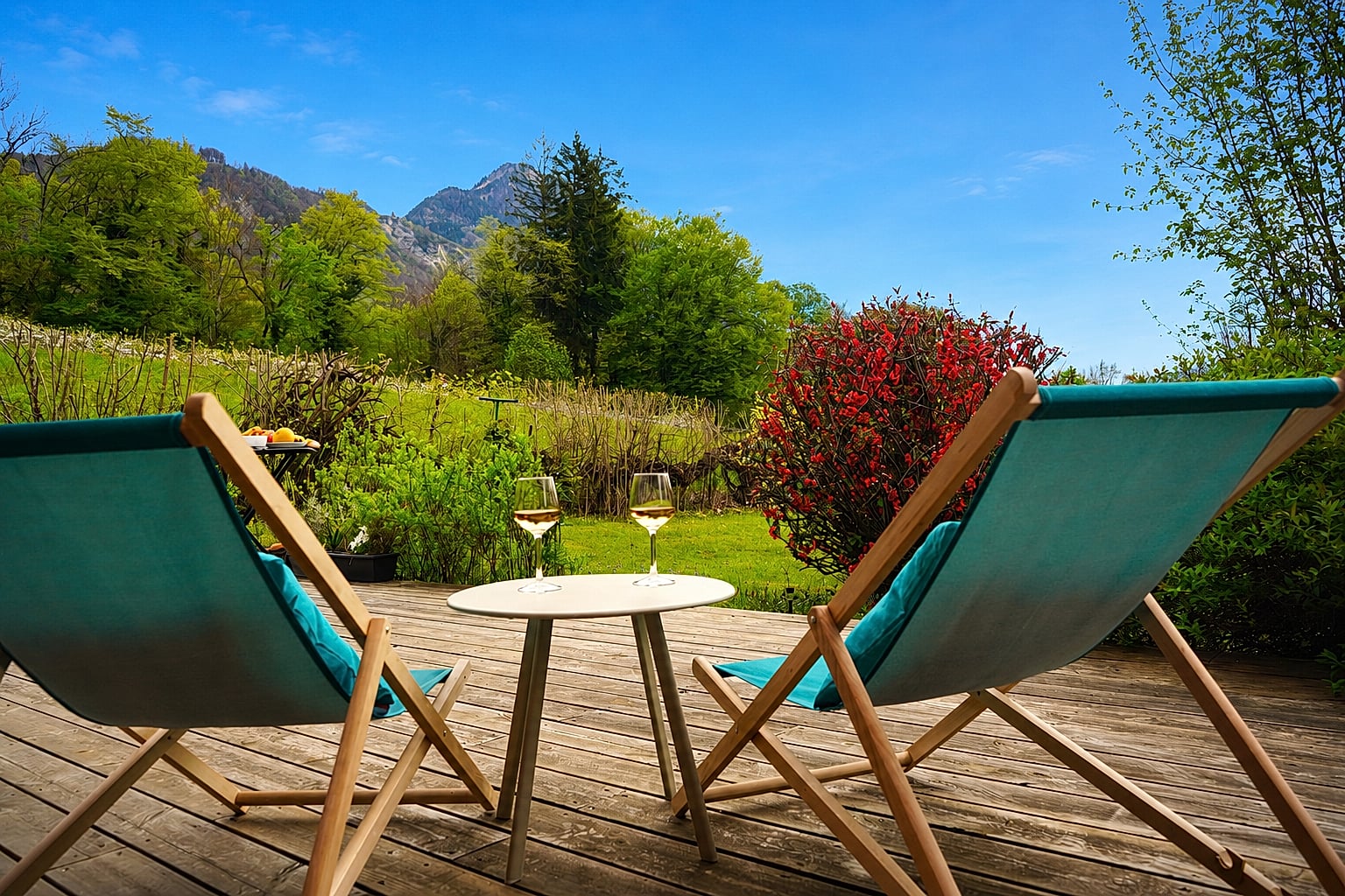 Terrasse du Gîte Vue Blanc — transats et verres de vin face au jardin et à la montagne