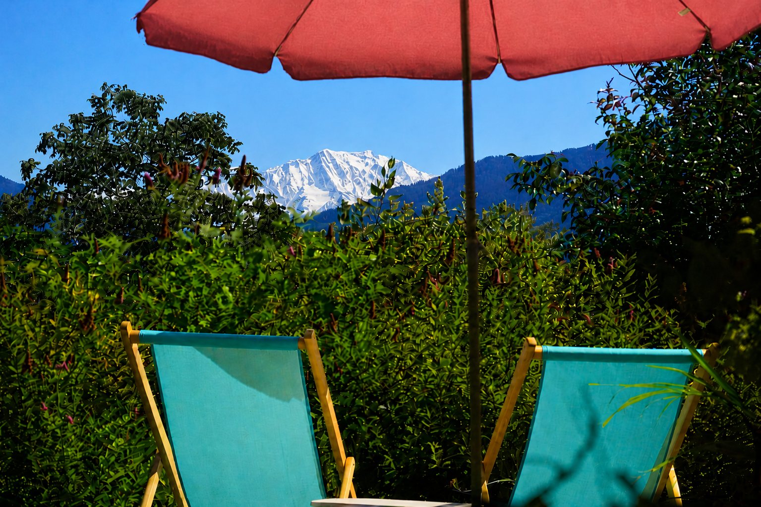Vue panoramique sur le Mont Blanc depuis la terrasse du Gîte côté Mont Blanc, transats et parasol